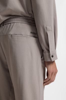 Tapered-fit trousers in waffle-structured stretch fabric, Grey