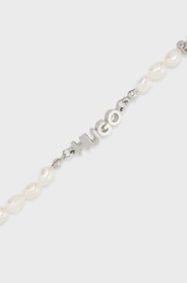 Pearl cuff with metal logo plaque, Silver tone