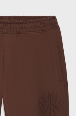 Bas de surv&ecirc;tement ample en molleton de coton avec logo artistique, Marron