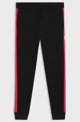 Pantalones de ch&aacute;ndal en felpa de algod&oacute;n con rayas laterales en contraste, Negro