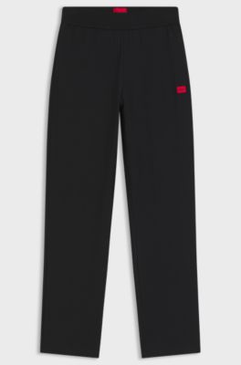 Tracksuit bottoms in stretch jersey with red logo label, Black