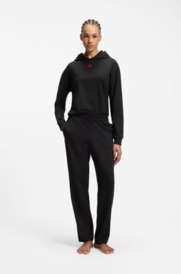 Tracksuit bottoms in stretch jersey with red logo label, Black