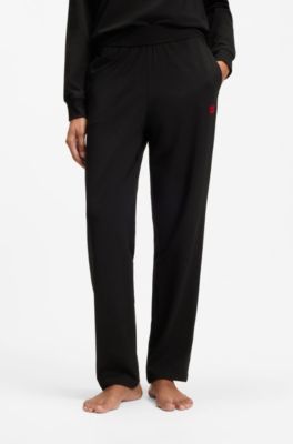 Tracksuit bottoms in stretch jersey with red logo label, Black