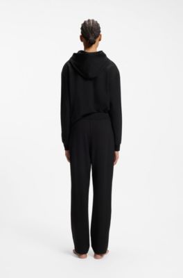 Tracksuit bottoms in stretch jersey with red logo label, Black