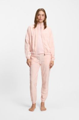 Cotton-blend tracksuit bottoms with all-over logo pattern, light pink