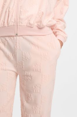 Cotton-blend tracksuit bottoms with all-over logo pattern, light pink