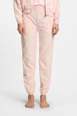 Cotton-blend tracksuit bottoms with all-over logo pattern, light pink