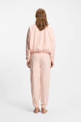 Cotton-blend tracksuit bottoms with all-over logo pattern, light pink