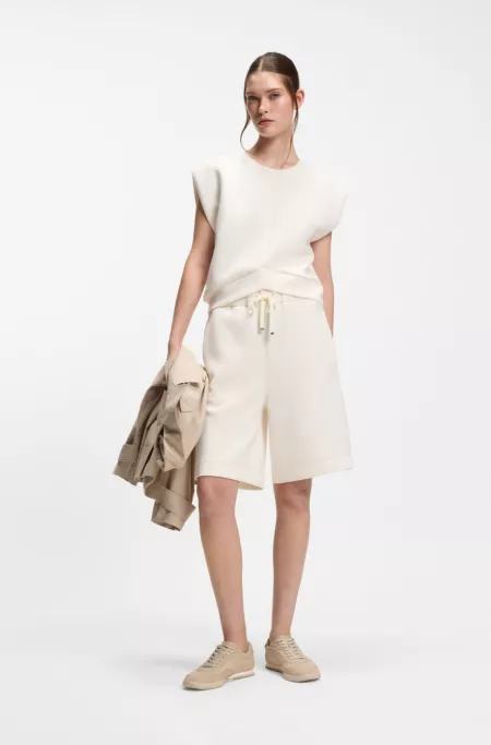 Sleeveless loose-fit sweatshirt with V-cut hemline