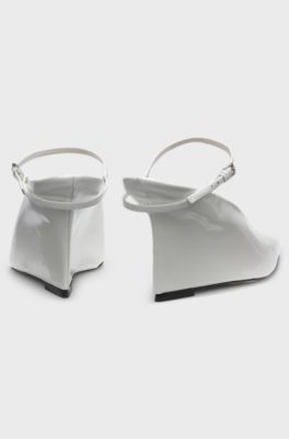 Glossy leather mules with wedge heel and strap, White