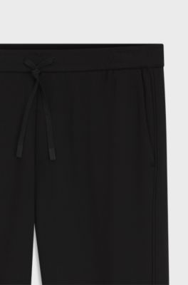 Regular-fit tracksuit bottoms with four-way stretch, Black