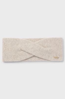 Strikket pandeb&aring;nd i kashmirblanding med metallogo, Lys beige