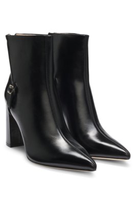 Pointed-toe boots in glossy leather with buckle detail