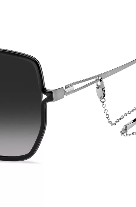 Black-frame sunglasses with forked temples and branded chain