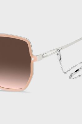 Nude-frame sunglasses with forked temples and branded chain, light pink
