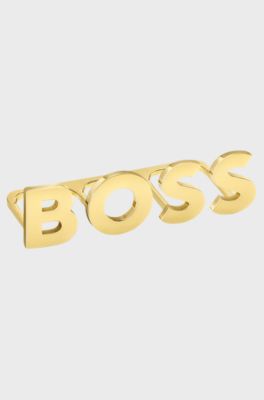 Light-gold tone knuckle ring with logo letters, Gold tone