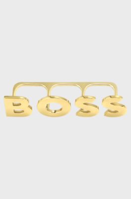 Light-gold tone knuckle ring with logo letters, Gold tone