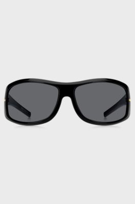 Gafas de sol negras de estilo m&aacute;scara con detalles met&aacute;licos dorados, Negro