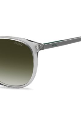 Transparent-grey sunglasses with green logo, Lysegr&aring;