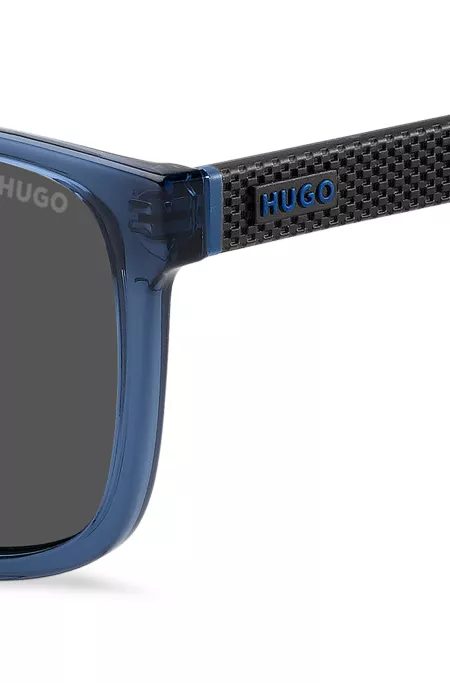 Transparent-blaue Sonnenbrille mit gemusterten Bügeln