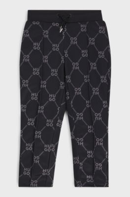 Kids' loose-fit tracksuit bottoms with stacked-logo print, Black Patterned
