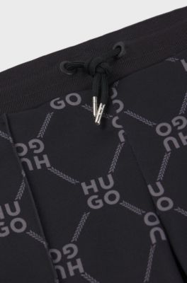 Kids' loose-fit tracksuit bottoms with stacked-logo print, Black Patterned