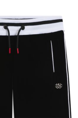 Kids' tracksuit bottoms in stretch velvet with striped ribbing, Black