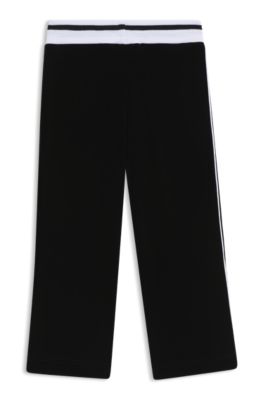 Kids' tracksuit bottoms in stretch velvet with striped ribbing, Black