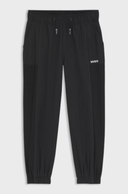 Kids' tracksuit bottoms with piping and logo, Black