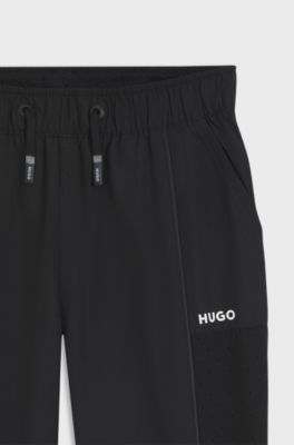 Kids' tracksuit bottoms with piping and logo, Black
