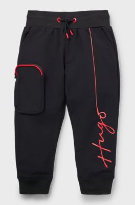 Kids' cuffed tracksuit bottoms with branding and patch pocket, Black