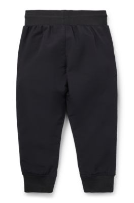 Kids' cuffed tracksuit bottoms with branding and patch pocket, Black