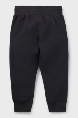 Kids' cuffed tracksuit bottoms with branding and patch pocket, Black