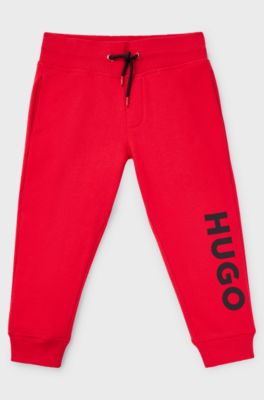 Kids' fleece tracksuit bottoms with vertical logo, Red