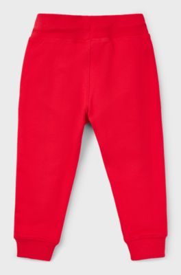 Kids' fleece tracksuit bottoms with vertical logo, Red