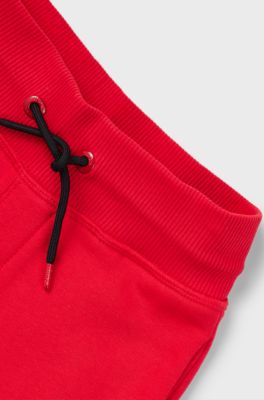Kids' fleece tracksuit bottoms with vertical logo, Red