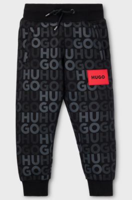 Kids' fleece tracksuit bottoms with all-over logo print, Black
