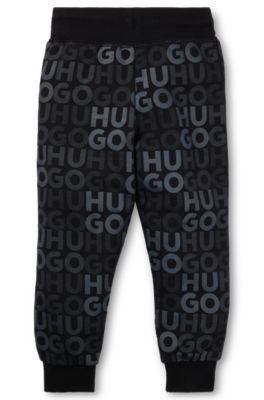 Kids' fleece tracksuit bottoms with all-over logo print, Black