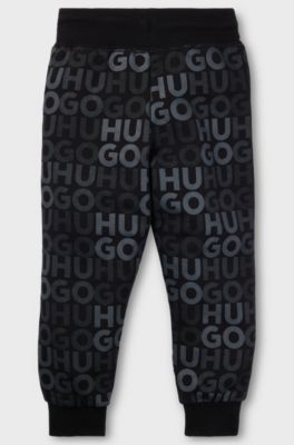 Kids' fleece tracksuit bottoms with all-over logo print, Black