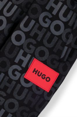 Kids' fleece tracksuit bottoms with all-over logo print, Black