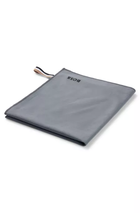Microfibre travel towel with signature-stripe strap
