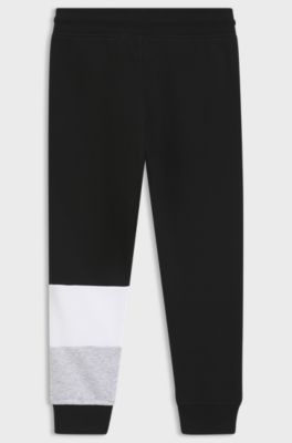 Kids' tracksuit bottoms with colour-blocking and logo print, Black