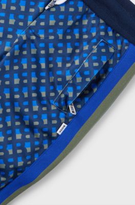 Kids' tracksuit bottoms with printed monograms and side stripes, Dark Blue