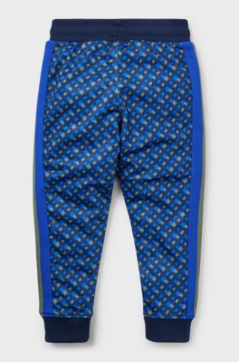 Kids' tracksuit bottoms with printed monograms and side stripes, Dark Blue
