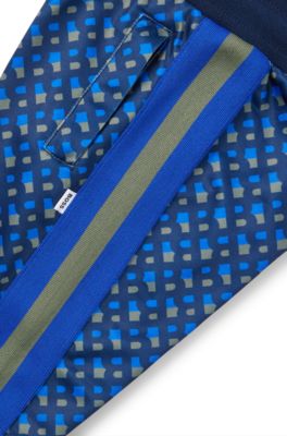 Kids' tracksuit bottoms with printed monograms and side stripes, Dark Blue