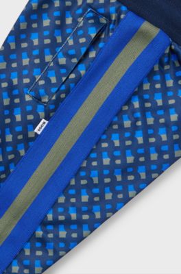 Kids' tracksuit bottoms with printed monograms and side stripes, Dark Blue