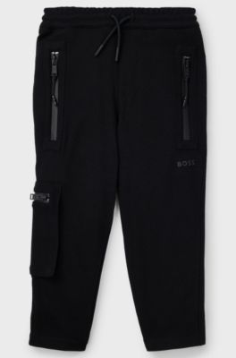 Kids' tracksuit bottoms in stretch piqu&eacute; with patch pocket, Black