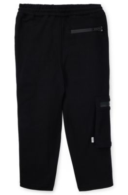 Kids' tracksuit bottoms in stretch piqu&eacute; with patch pocket, Black
