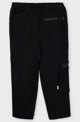 Kids' tracksuit bottoms in stretch piqu&eacute; with patch pocket, Black