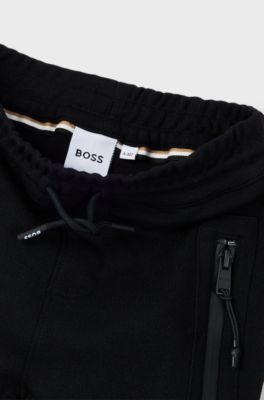 Kids' tracksuit bottoms in stretch piqu&eacute; with patch pocket, Black
